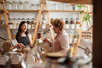 Two women are having a conversation in a refill shop