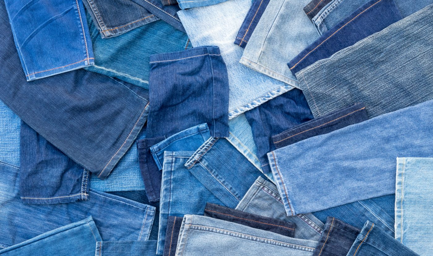 Different shades of blue denim jeans, many of which are left pieces over from sewing repairs.