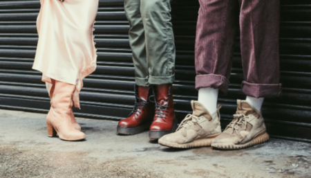 Love Not Landfill charity pop-up shop to show the best second-hand clothes London has to offer. Shot of shoes on 3 models: pink cowboy boots, red Doc Martens and beige Yeezy trainers